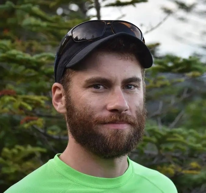 A photo of Tim Duclos standing in the woods.